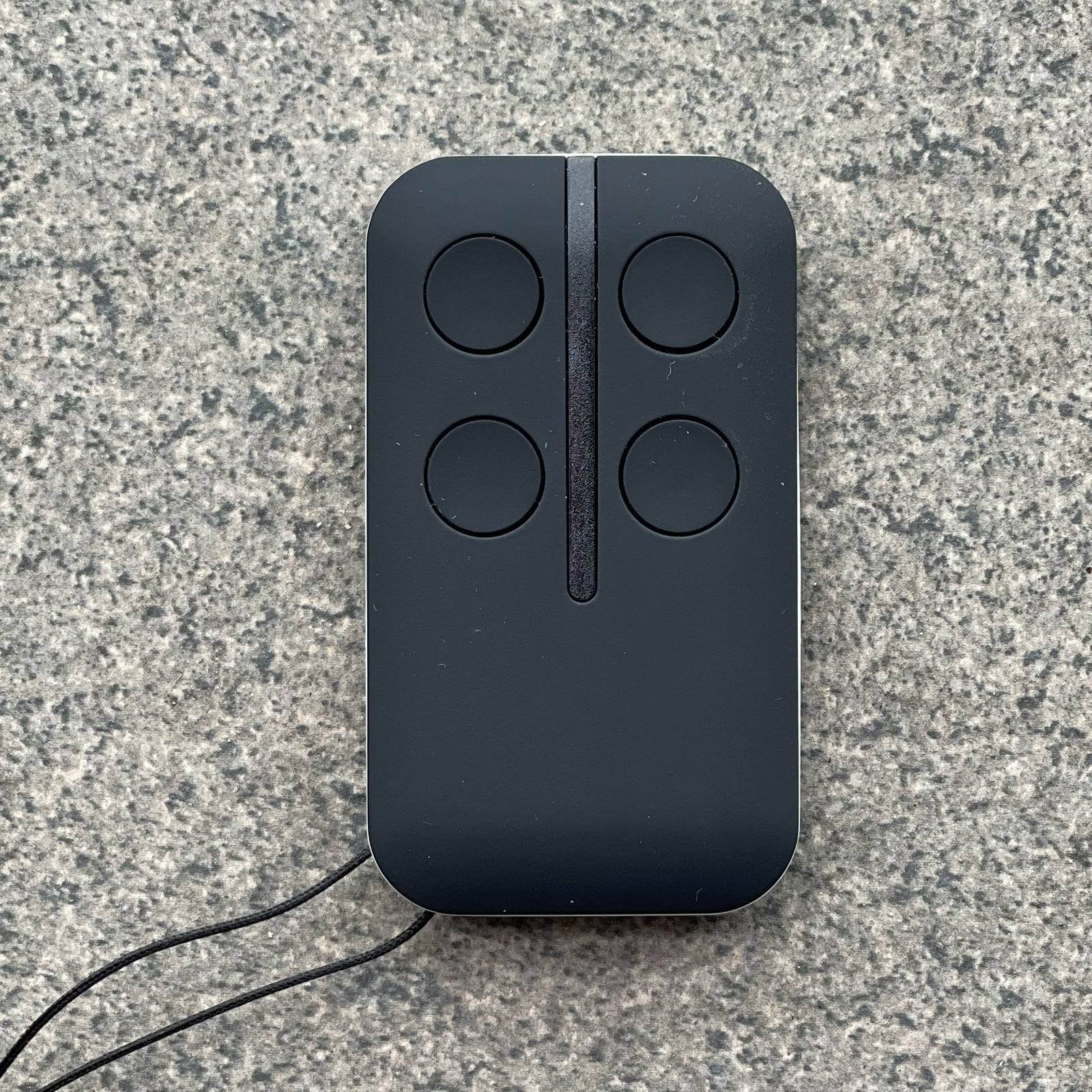 ATA PTX4 replacement garage door remote with four buttons, compatible with multiple GDO models, shown on a textured surface.