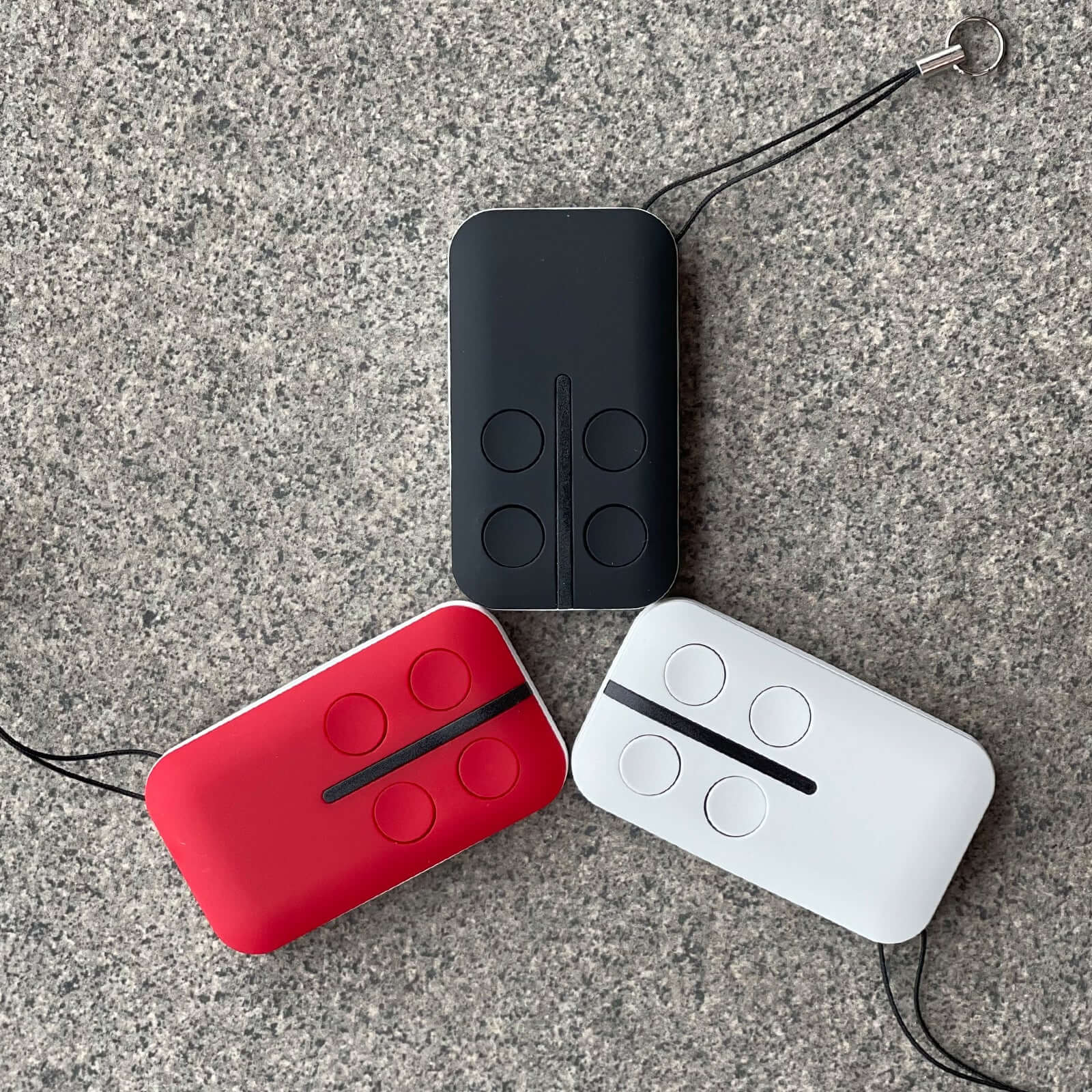 Black, red, and white BFT compatible Mitto garage door remotes with four buttons, ideal for Garageway applications.