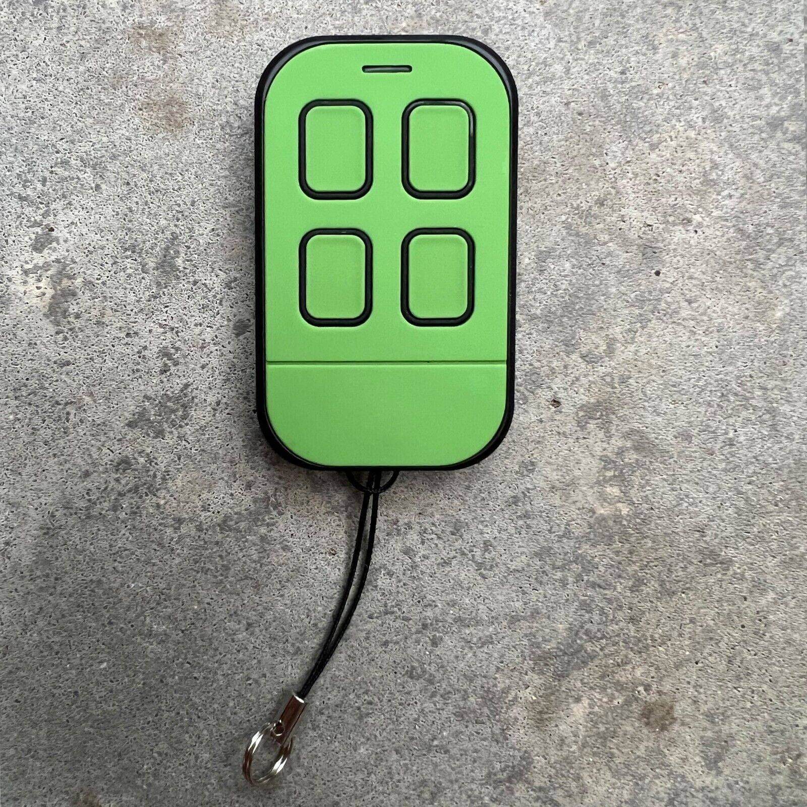 Merlin M842 compatible green remote control with four buttons on a gray surface.
