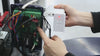 Person installing a control panel for a Smart RITROX K2208 sliding gate opener with Wi-Fi connectivity.